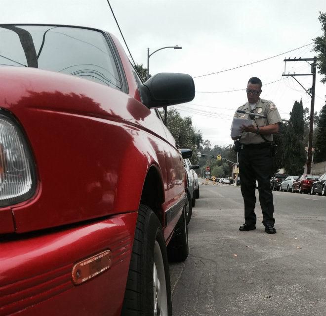 Parking enforcement officer writing a ticket